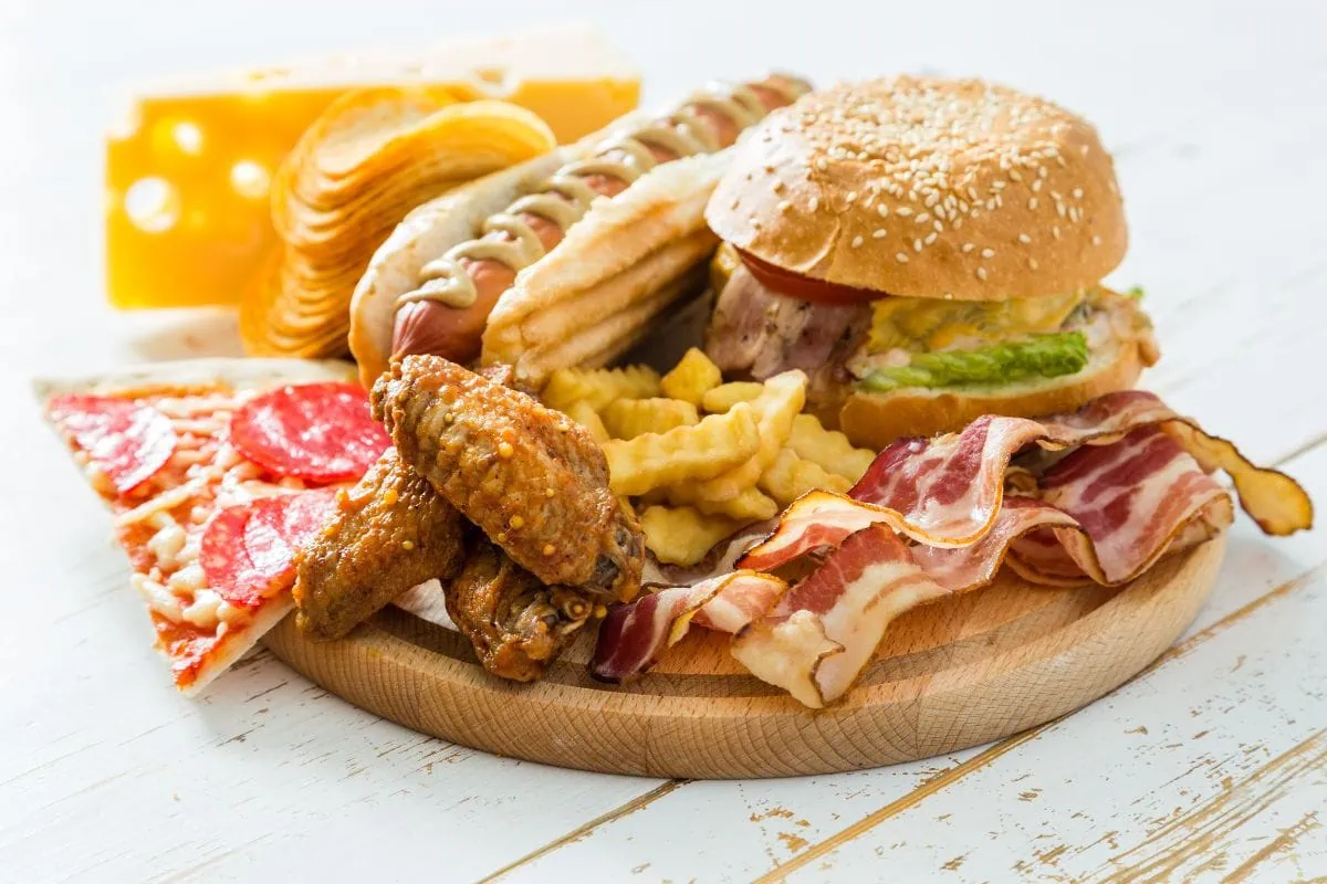 Fast food platter with burger, pizza, hot dog, fries, bacon, and wings.