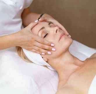 Woman receiving a relaxing facial massage and skin treatment.