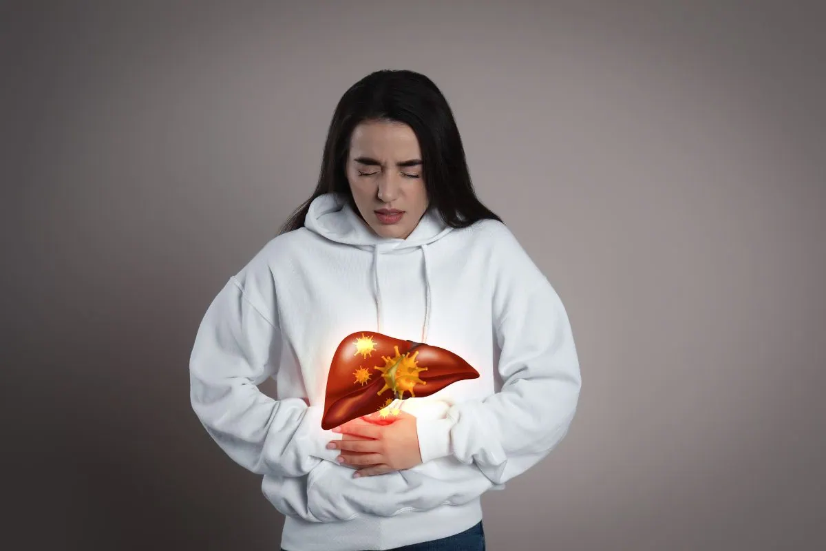 Woman holding abdomen with glowing infected liver graphic.