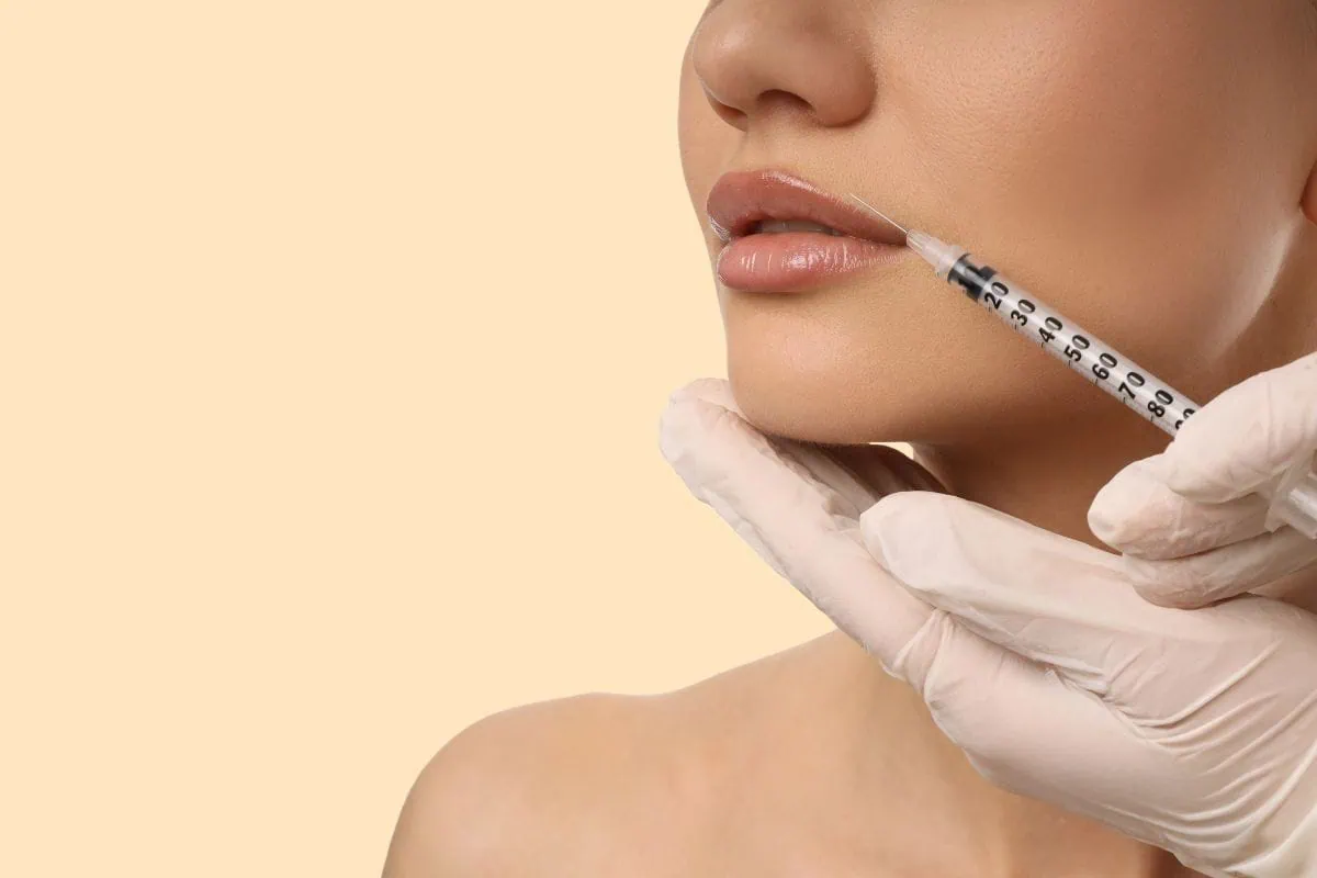 Close-up of a woman receiving a cosmetic lip injection procedure.