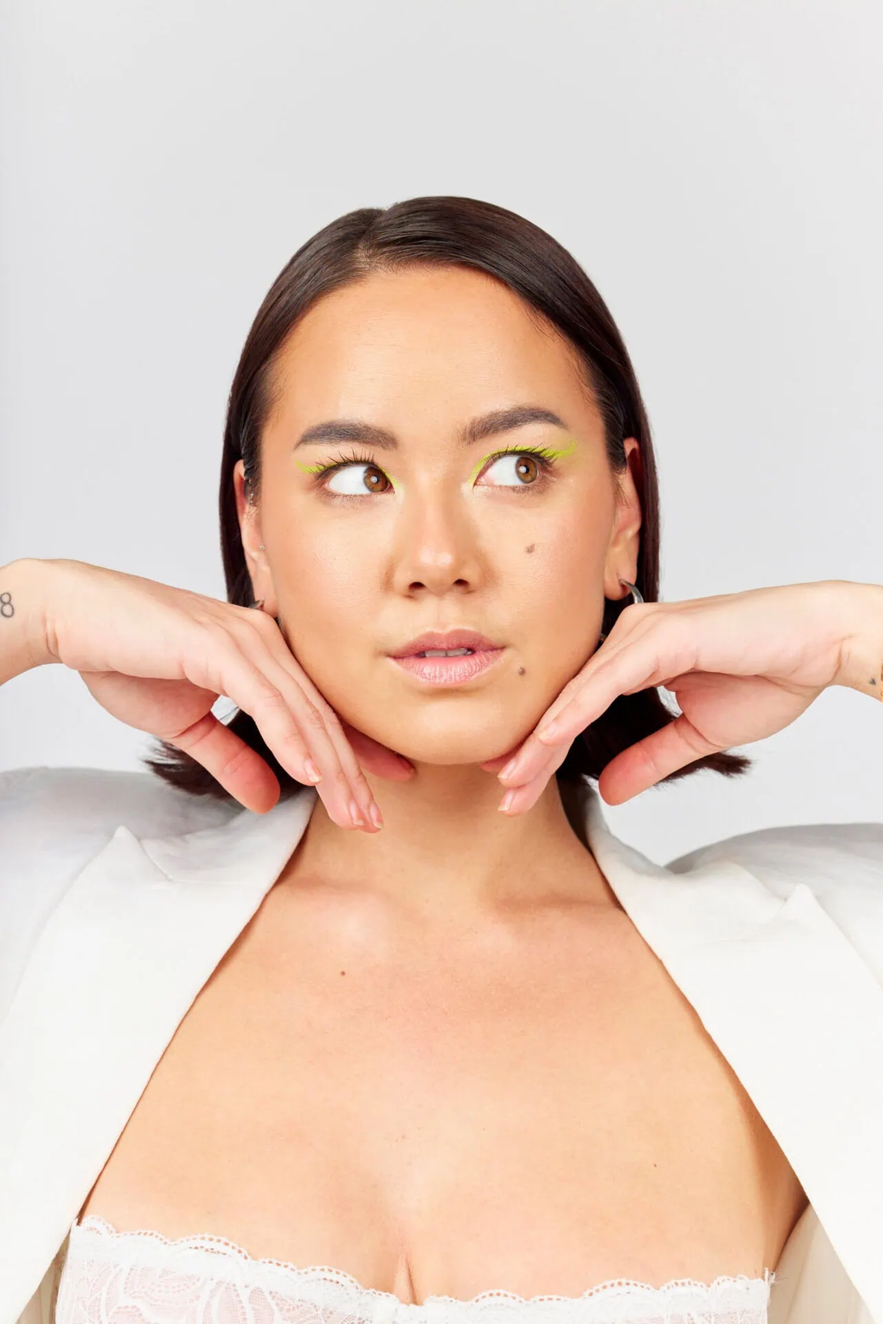 Woman with clear skin and neon eyeliner framing her face