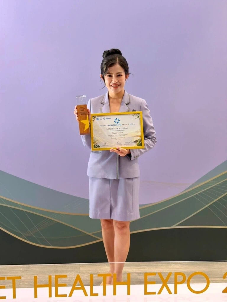 Woman in light gray suit holding a certificate and a trophy at Phuket Health Expo 2026.
