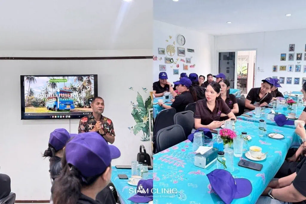 Group of people wearing purple caps attending a presentation in a bright room with a large screen and wall decorations.